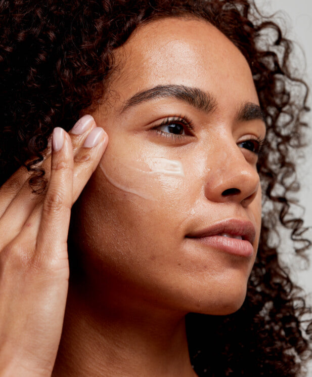 woman applying serum to face